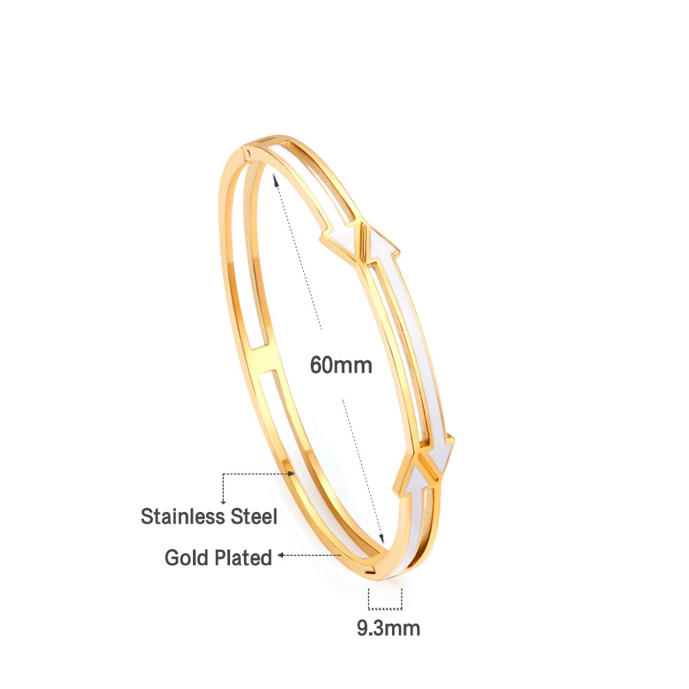 gold colored hard bracelet with directional arrows