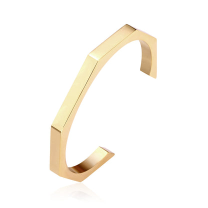Gold-tone steel with an angular face on an open-end rigid bracelet.